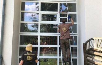 2 Personen reinigen eine Fassade
